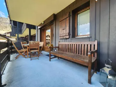 a porch with a bench and a table and chairs at Appartement confort 4 pers avec balcon et garage, coeur de Samoëns - FR-1-629-101 in Samoëns