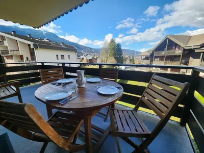 a wooden table and chairs on a balcony at Appartement confort 4 pers avec balcon et garage, coeur de Samoëns - FR-1-629-101 in Samoëns