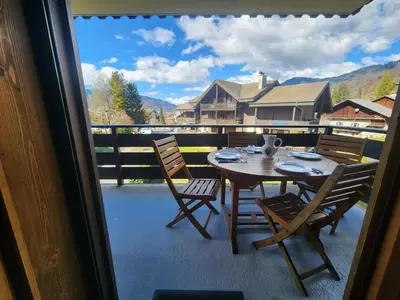a table and chairs on a balcony with a view at Appartement confort 4 pers avec balcon et garage, coeur de Samoëns - FR-1-629-101 in Samoëns
