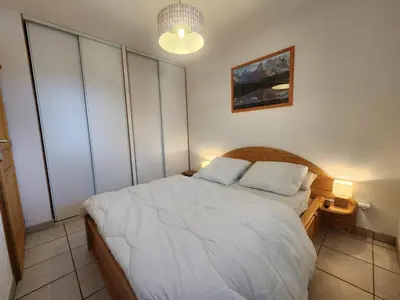 a bedroom with a white bed with two pillows at Appartement confort 4 pers avec balcon et garage, coeur de Samoëns - FR-1-629-101 in Samoëns