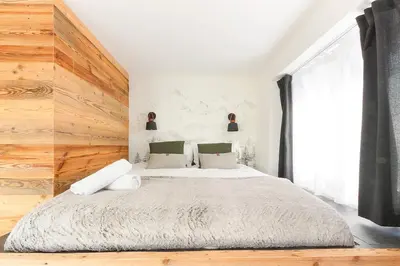 a bedroom with a large bed with a wooden wall at Les Cîmes du Mont-Blanc in Chamonix-Mont-Blanc