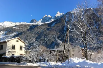 a house in front of a mountain with snow at Les Cîmes du Mont-Blanc in Chamonix-Mont-Blanc