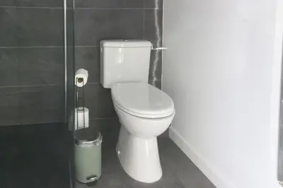 a bathroom with a toilet and a trash can at Les Cîmes du Mont-Blanc in Chamonix-Mont-Blanc