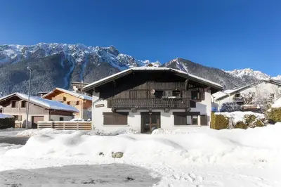 a house in the snow with mountains in the background at Les Cîmes du Mont-Blanc in Chamonix-Mont-Blanc