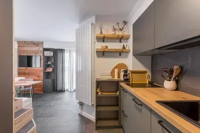 a kitchen with white cabinets and a counter top at Les Cîmes du Mont-Blanc in Chamonix-Mont-Blanc