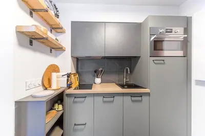 a small kitchen with gray cabinets and a sink at Les Cîmes du Mont-Blanc in Chamonix-Mont-Blanc