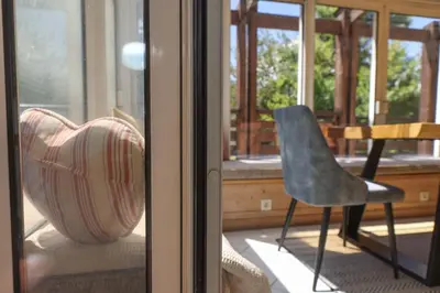a chair sitting on a porch next to a window at Chalet Belle-Sofianna in Saint-Gervais-les-Bains