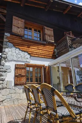 two chairs sitting on a deck in front of a house at Chalet Belle-Sofianna in Saint-Gervais-les-Bains