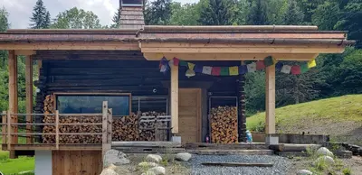 a log cabin with a bunch of wood in it at Chalet L'Oratoire & Mazot - Renovated Historic Chalet - Huge Garden & Separate Cabin for 2 in Les Houches