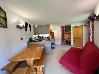 a living room with a wooden table and a red couch at Appartement 6 personnes avec balcon proche jardin d'enfants - FR-1-642-62 in Morillon