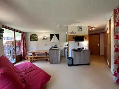 a living room with a red couch and a kitchen at Appartement 6 personnes avec balcon proche jardin d'enfants - FR-1-642-62 in Morillon