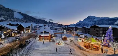 a town covered in snow with a christmas tree at Vintage chic -central, wifi, mountain view-BelleVue3 in Les Carroz d'Araches