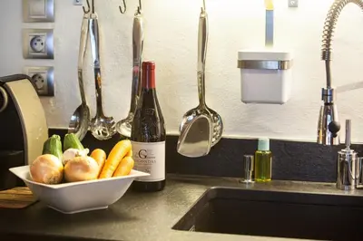 a kitchen counter with a bowl of vegetables and a bottle of wine at Apartment Blaitiere - luxurious 2 bed apartment in Chamonix-Mont-Blanc