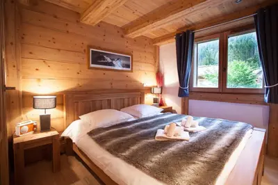 a bedroom with a bed in a log cabin at Apartment Blaitiere - luxurious 2 bed apartment in Chamonix-Mont-Blanc