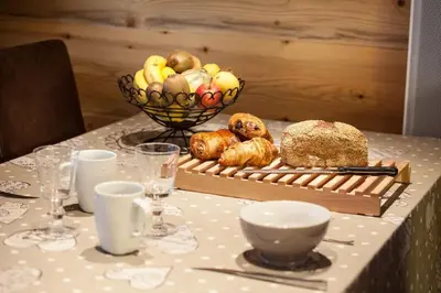 a table with a bowl of bread and a basket of fruit at Apartment Blaitiere - luxurious 2 bed apartment in Chamonix-Mont-Blanc