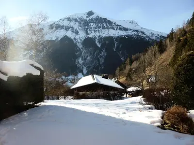 a snow covered cabin with a mountain in the background at Résidence Les Carlines - Carlines 3 MAE-8424 in Les Contamines-Montjoie