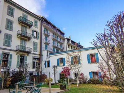 a large white building with blue shuttered windows at Apartment Le Paccard-2 by Interhome in Chamonix-Mont-Blanc