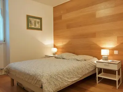 a bedroom with a large wooden headboard and a bed at Apartment Le Paccard-2 by Interhome in Chamonix-Mont-Blanc