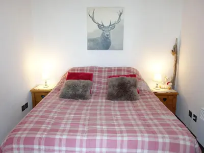 a bed with a red and white plaid blanket at Apartment Bel Alp 23 by Interhome in Saint-Gervais-les-Bains