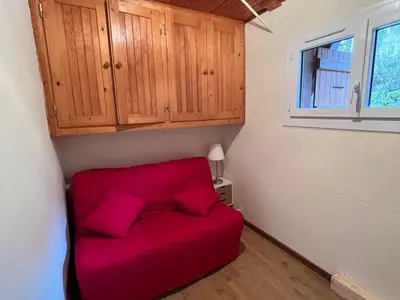 a red couch in a small room with a window at Appartement pour 14 pers, rénové, animaux acceptés, parking - FR-1-624-92 in Samoëns