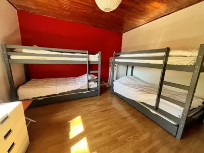 two bunk beds in a room with a red wall at Appartement pour 14 pers, rénové, animaux acceptés, parking - FR-1-624-92 in Samoëns