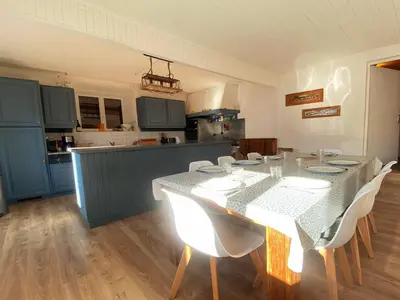 a dining room with a table and chairs and a kitchen at Appartement pour 14 pers, rénové, animaux acceptés, parking - FR-1-624-92 in Samoëns
