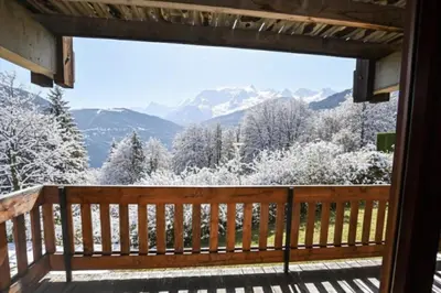 a view from the deck of a cabin with snow covered trees at Apartment With View On The Mont Blanc in Saint-Gervais-les-Bains