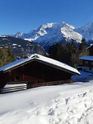 a snow covered cabin with mountains in the background at Apartment With View On The Mont Blanc in Saint-Gervais-les-Bains