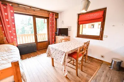 a room with a table and a bed and a window at Apartment With View On The Mont Blanc in Saint-Gervais-les-Bains
