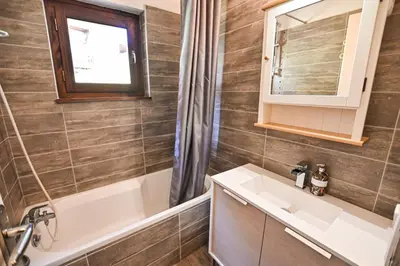 a bathroom with a sink and a tub and a mirror at Apartment With View On The Mont Blanc in Saint-Gervais-les-Bains