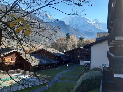 a view of the mountains from the backyard of a house at Appartement meublé avec vue sur les montagnes et piscine l'été in Saint-Gervais-les-Bains