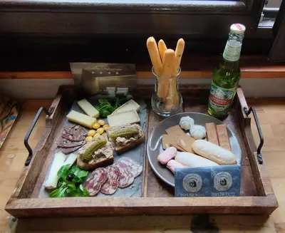 a tray with a plate of food and a bottle of beer at Calme et sérénité - établissement classé in Sixt
