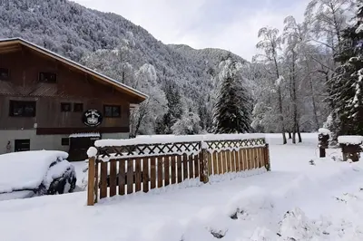 a fence covered in snow in front of a house at Calme et sérénité - établissement classé in Sixt