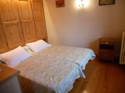 a small bedroom with a bed and a wooden floor at La Tour in Combloux