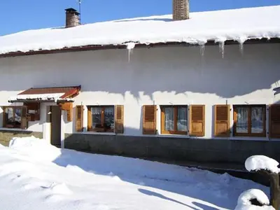 a house with snow on the side of it at La Tour in Combloux