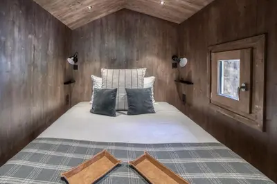 a bedroom with a bed in a wooden wall at Le Chalet Georges in Chamonix-Mont-Blanc