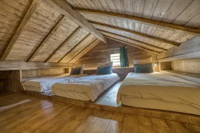 two beds in a room with wooden ceilings at Le Chalet Georges in Chamonix-Mont-Blanc