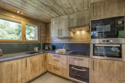 a kitchen with wooden cabinets and a stove at Le Chalet Georges in Chamonix-Mont-Blanc
