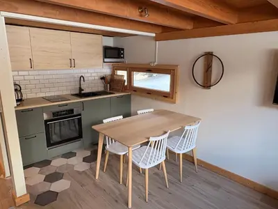 a kitchen with a wooden table and chairs at Résidence Grand Roc - Bruyères 20 in Chamonix-Mont-Blanc