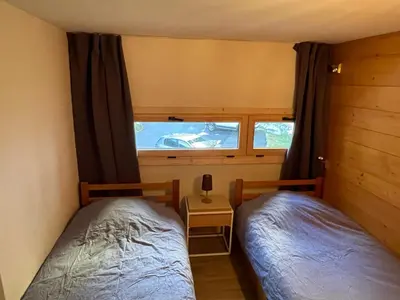 two beds in a small room with a window at Résidence Grand Roc - Bruyères 20 in Chamonix-Mont-Blanc