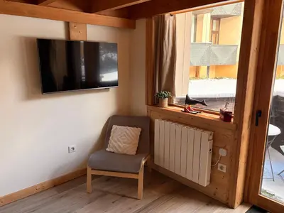 a room with a chair and a tv and a window at Résidence Grand Roc - Bruyères 20 in Chamonix-Mont-Blanc