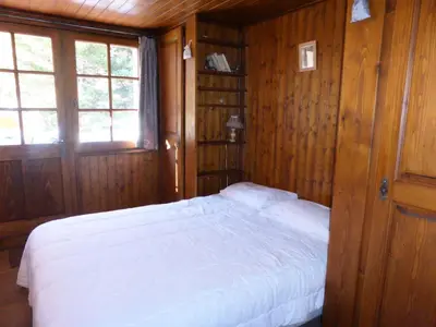 a bedroom with a white bed in a wooden room at Chalet Santa Claus - Chalet Santa Claus MAE-7284 in Les Contamines-Montjoie
