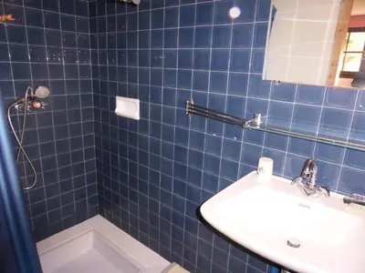 a blue tiled bathroom with a sink and a mirror at Chalet Santa Claus - Chalet Santa Claus MAE-7284 in Les Contamines-Montjoie