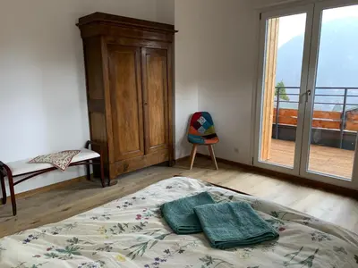 a bedroom with a bed with two green towels on it at New Spacious Appart. Incredible view of Mt Blanc in Passy