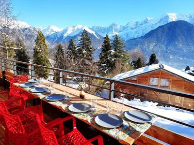 a table and chairs on a balcony with mountains at New Spacious Appart. Incredible view of Mt Blanc in Passy