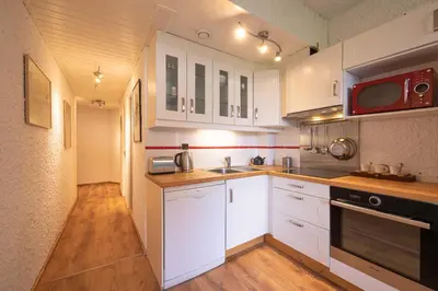 a kitchen with white cabinets and a microwave at Cocon du Lachat in Saint-Gervais-les-Bains