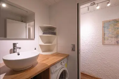 a bathroom with a sink and a washing machine at Cocon du Lachat in Saint-Gervais-les-Bains