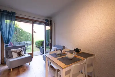 a living room with a table and a chair and a dining table and a table at Cocon du Lachat in Saint-Gervais-les-Bains