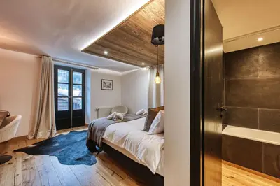 a bedroom with a bed and a tub in a room at Le Marti in Chamonix-Mont-Blanc