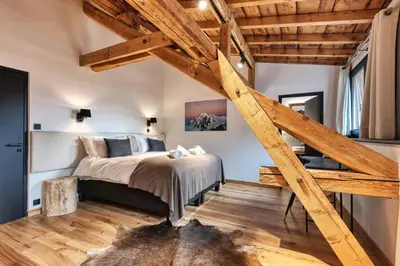 a loft bedroom with a bed and wooden beams at Le Marti in Chamonix-Mont-Blanc